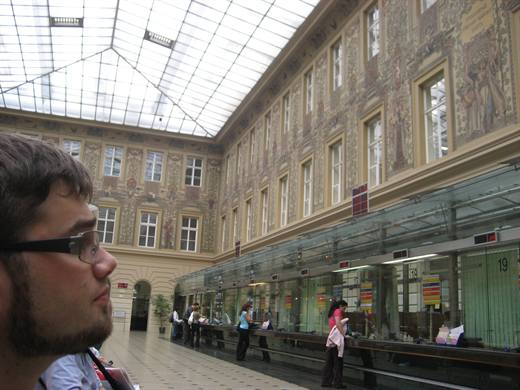 Pola staunt in der Schalterhalle der Prager Hauptpost, Briefmarken kaufen als Sightseeing
