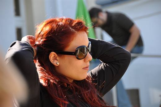 Julia richtet die rote Mähne in der Sonne, Filmstar-Sonnenbrille inklusive