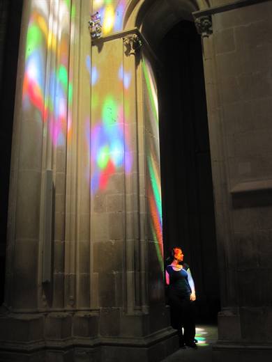 Julia im Lichterkonfetti der Kirchenfenster, für einmal tragen die Säulen Farbe
