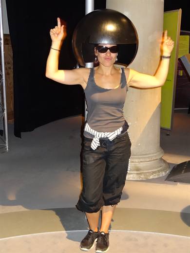 Julia unter der Riesentrockenhaube, Sonnenbrille auf und beide Discofinger oben