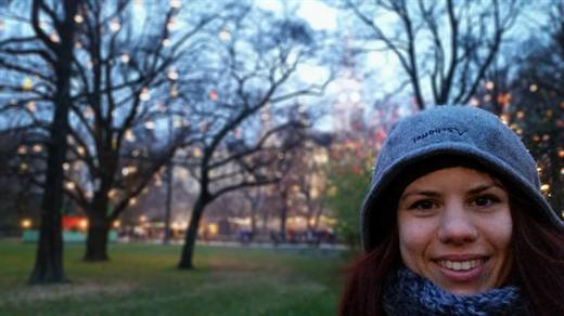 Julia dick eingepackt vor leuchtenden Bäumen, der Advent glitzert im Park