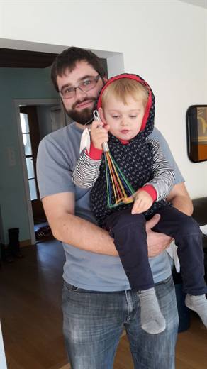 Pola mit kleinem Gast auf dem Arm, der bunte Schwingbesen ist das Spielzeug der Stunde
