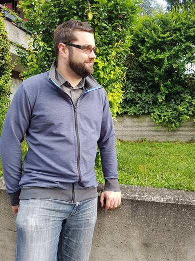 Pola posiert in der blauen Jacke vor sattgrüner Hecke, der Mai macht auf Hochglanz