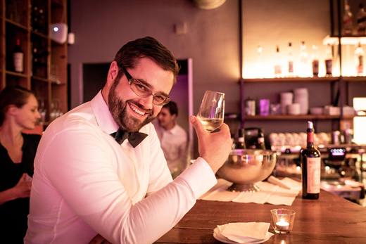 Weisses Hemd, schwarze Fliege, gehobenes Glas: Pola in bester Feierlaune an der Bar